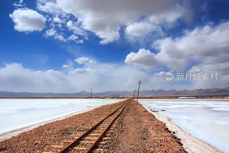 铁路在阳光下穿过盐碱地沙漠