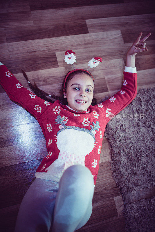 可爱的小女孩躺在地板上，微笑在圣诞之夜