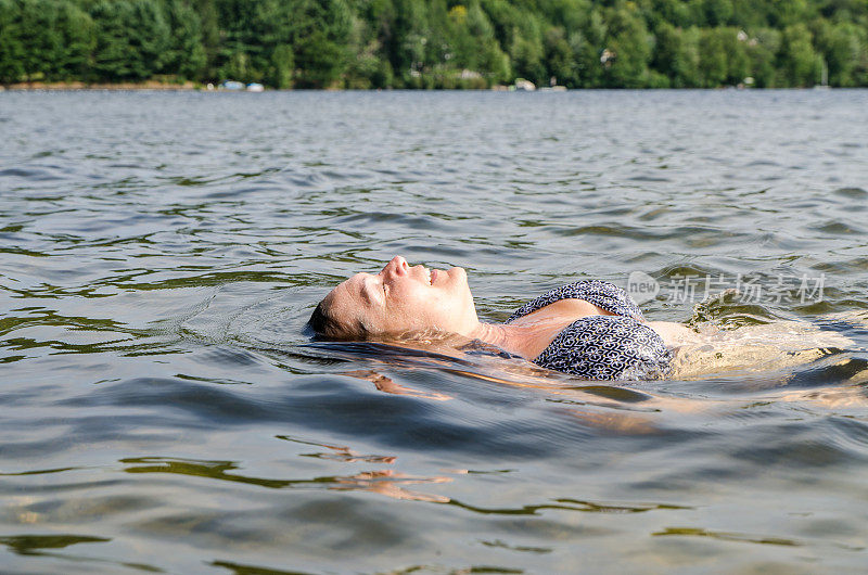 在夏日的热浪中，一名女子在湖中游泳