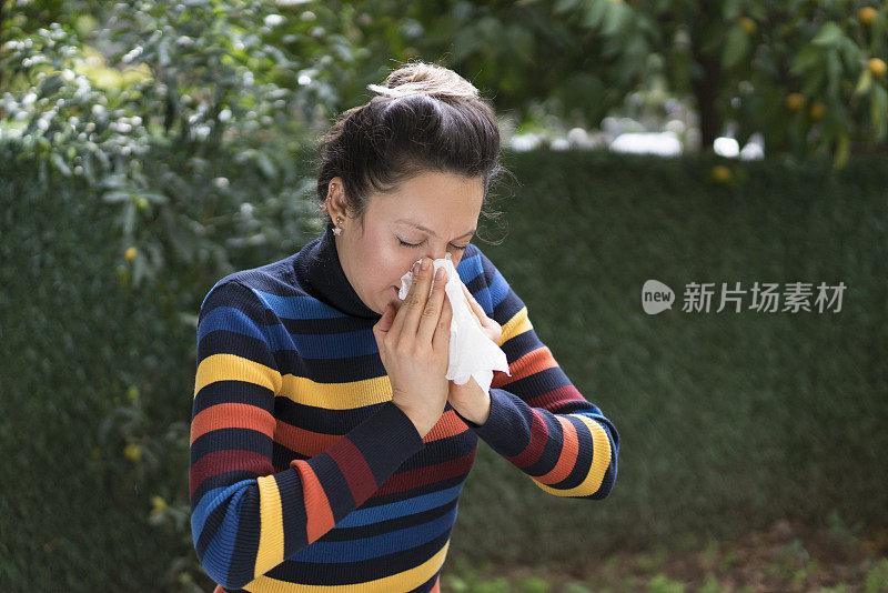 用纸巾擤鼻子的女人