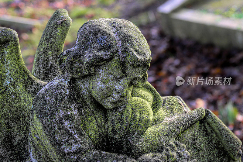 绿色的苔藓覆盖着古老的石头天使在萨里墓地