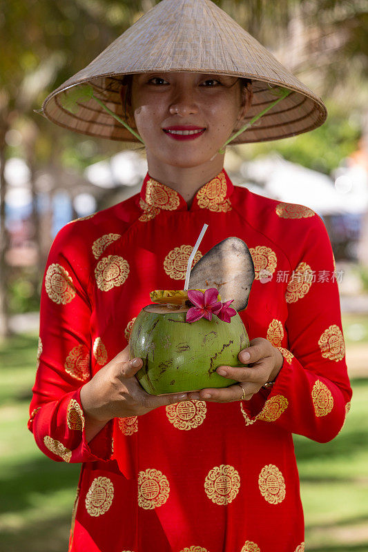 异国情调的传统越南女孩，同时提供新鲜的椰果和鲜花