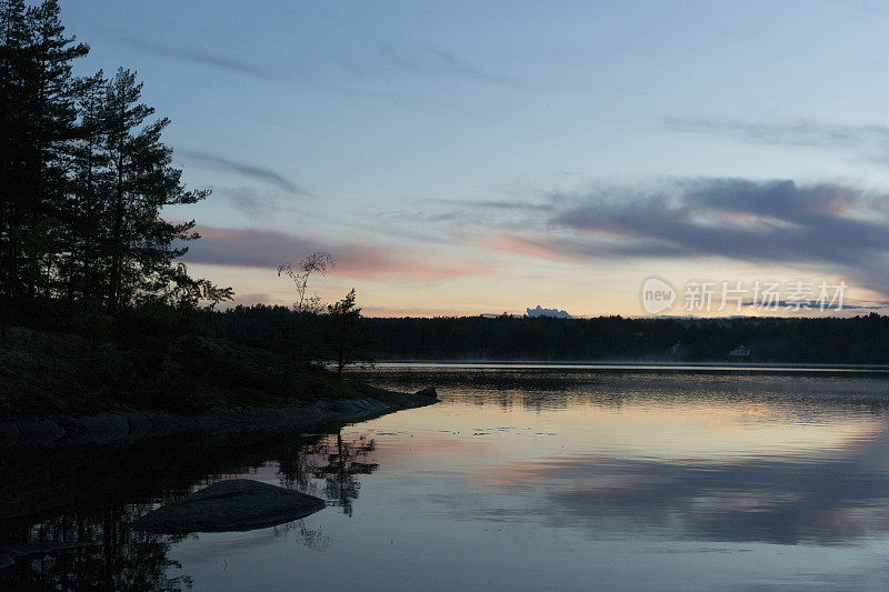 夏日傍晚，瑞典平静的湖面上的日落