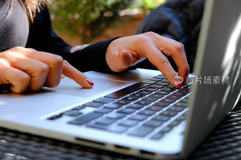女性在笔记本电脑键盘上打字的特写