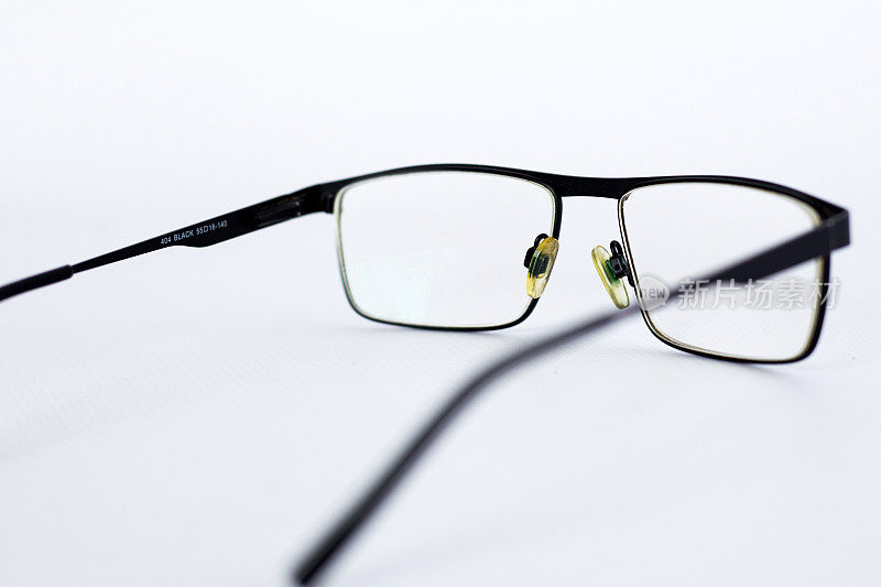 为视障、弱视者准备的眼镜。黑框白底非球面散光镜片眼镜。