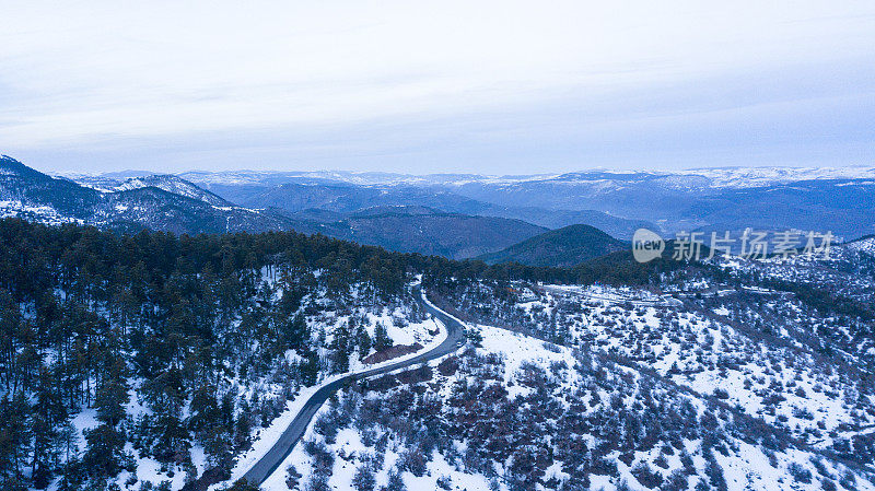 无人机拍摄的美丽雪山冬季弯弯曲曲的道路