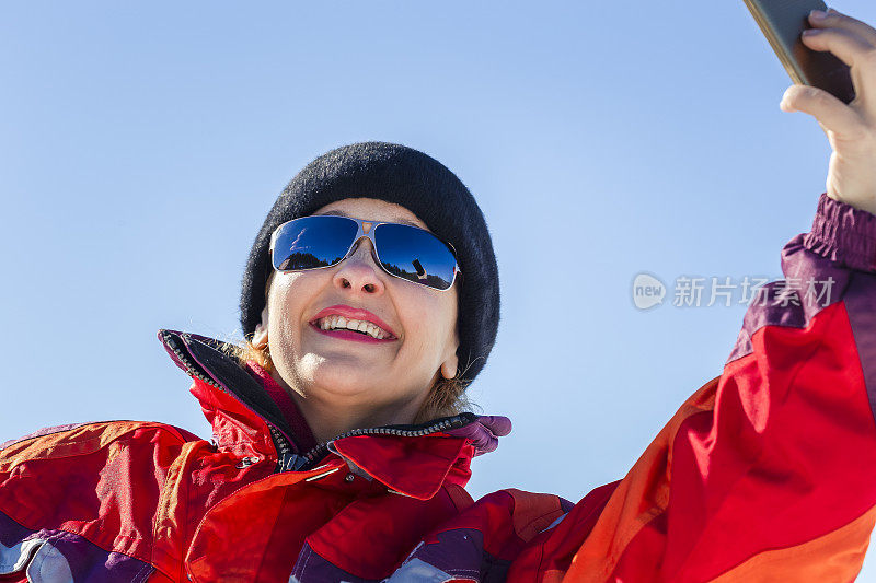 快乐的女人在雪地里徒步自拍