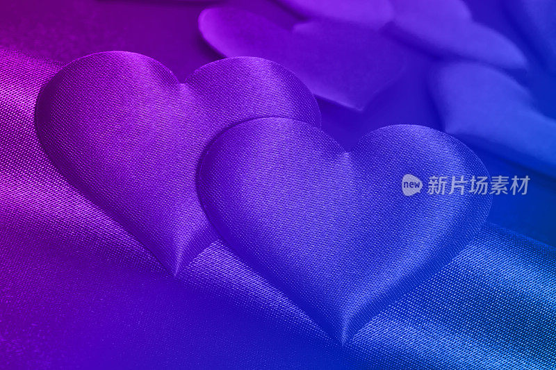 浪漫的背景(紫蓝色绸缎上的一对心形绸缎)