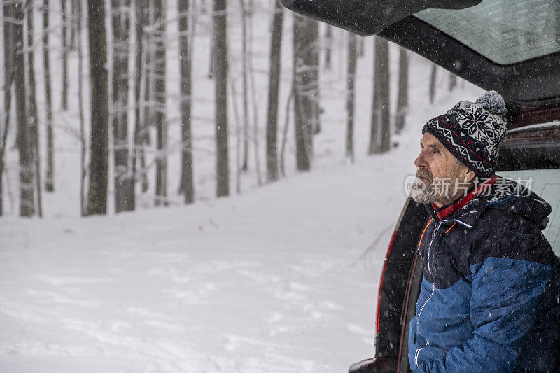 一个人坐在雪地里的后备箱里