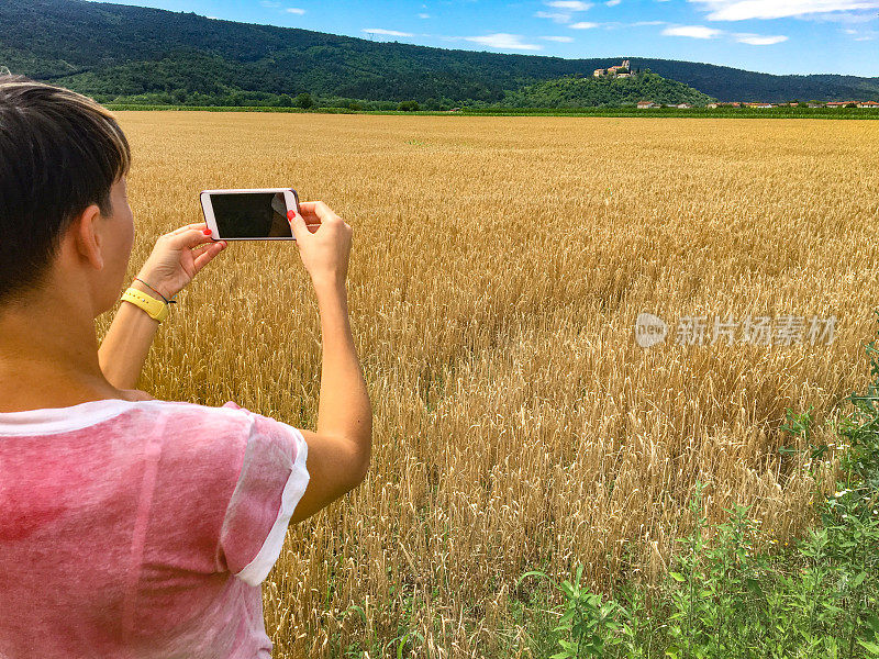 成年女性用智能手机拍摄风景