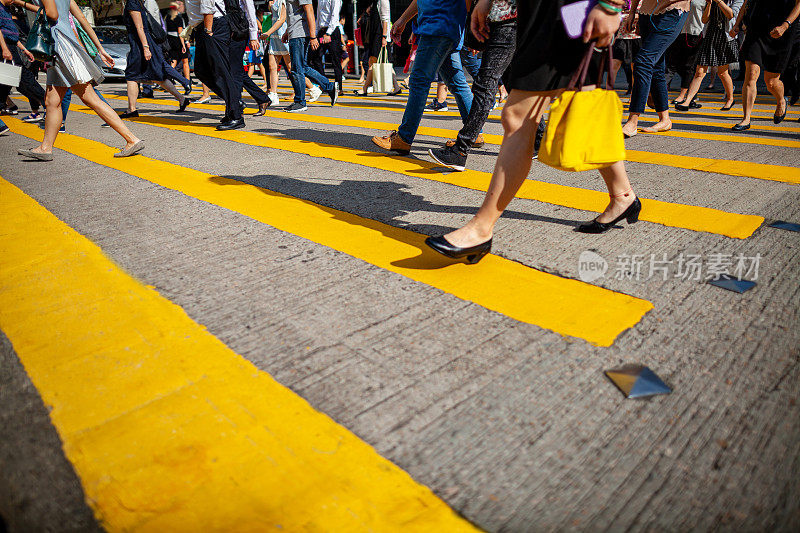 难以辨认的人群穿过人行横道，低角度的香港