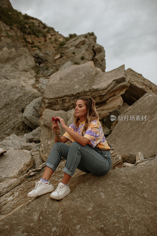 年轻女子坐在岩石上