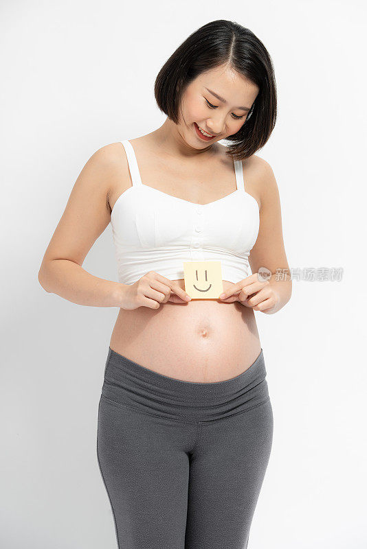 肚子上贴着纸条的漂亮孕妇。