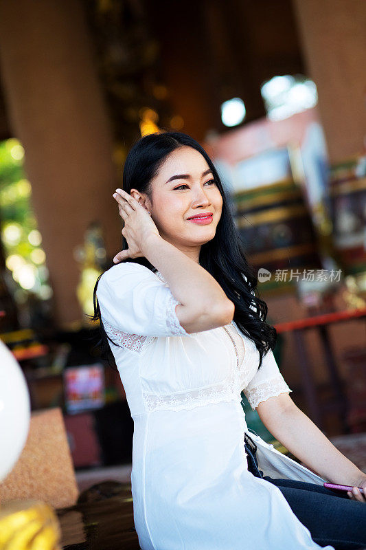 微笑的泰国女人用手梳理头发
