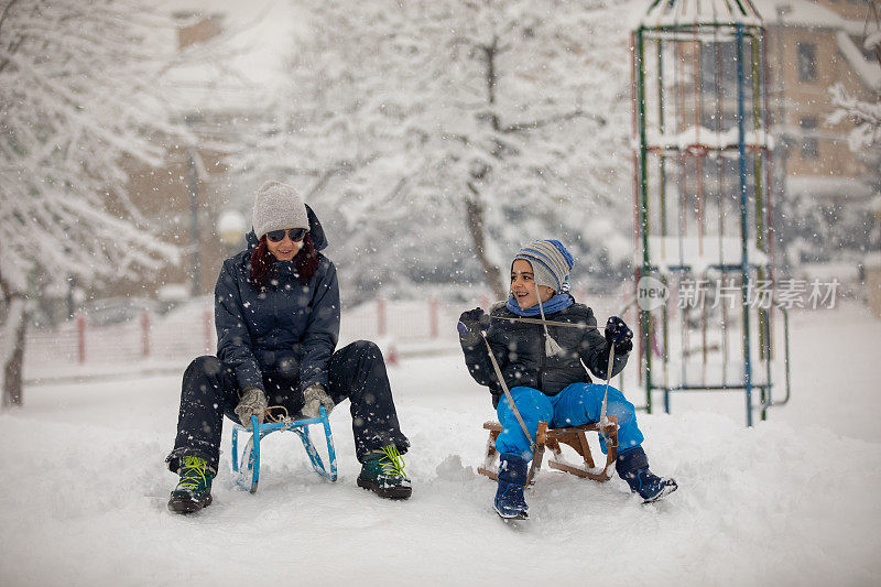 妈妈和儿子在公园玩雪橇