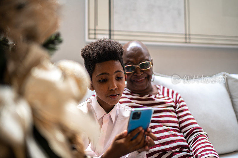 孙子和奶奶在家里用智能手机进行视频通话
