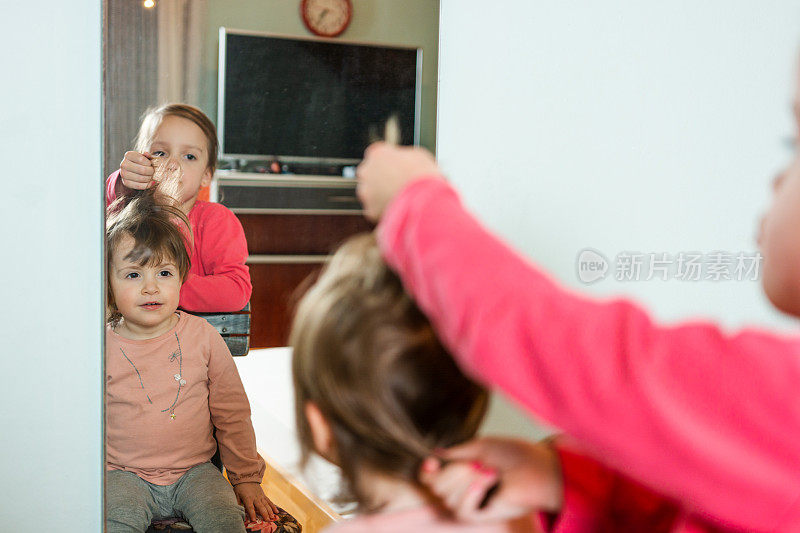 孩子正在给她的小妹妹做发型