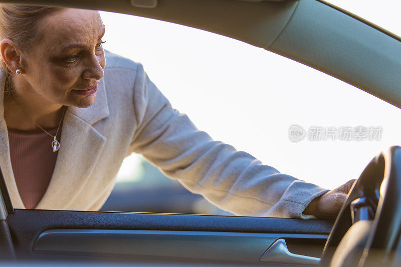 一位女士正在检查她要买的汽车