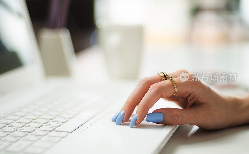 女性的手在笔记本电脑上工作。办公室白色桌面，平躺。在家远程工作。自由职业者的笔记本电脑，咖啡，眼镜。远程教育的概念，隔离，女性商务，网上购物