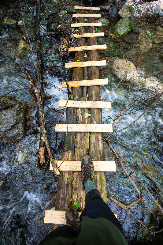 POV透视视图向下看脚跨木桥在河上