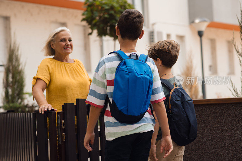 奶奶在和要上学的孙子们说再见。