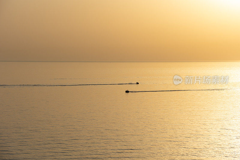日落时海上摩托艇的无人机视野