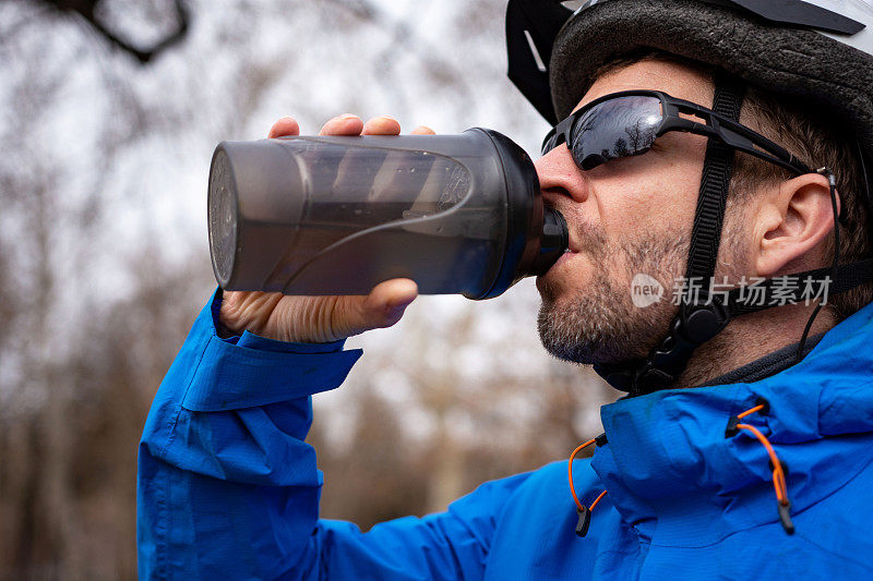 中年男性山地自行车手在喝水