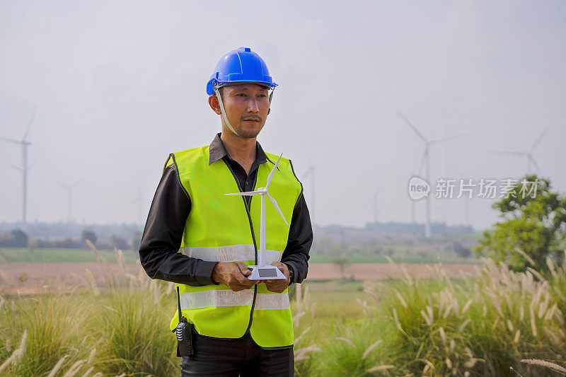 在发电厂工作的蓝领工人。风车。