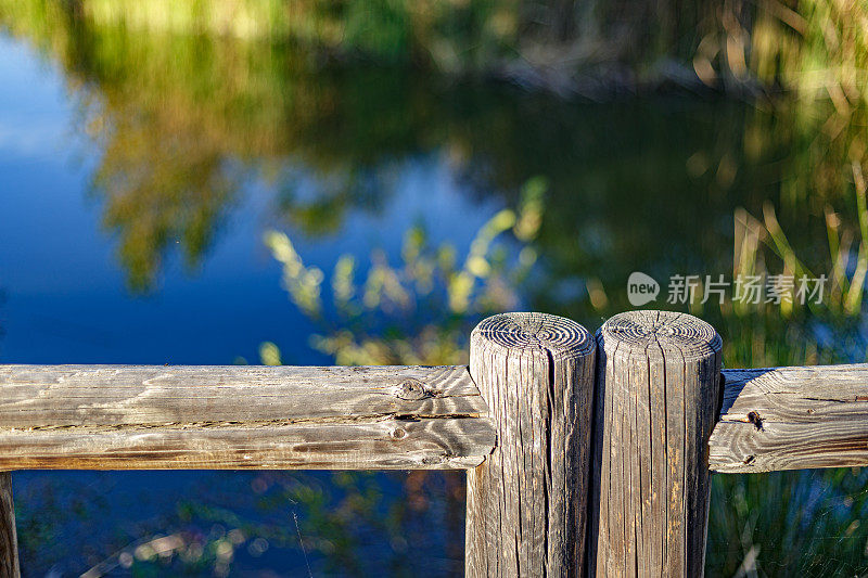 秋天日落时湖周围的木栅栏。自然环境。Presillas自然公园。Alcorcon,马德里,西班牙。