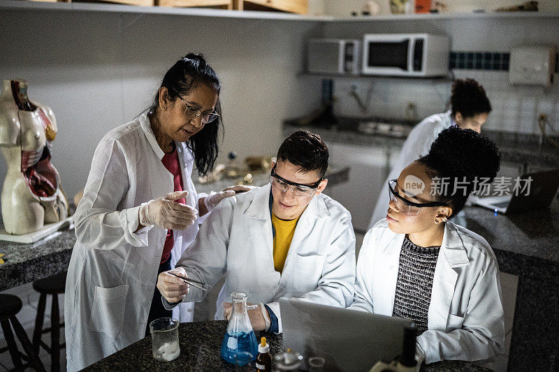化学老师在学校或大学的实验室里教学生