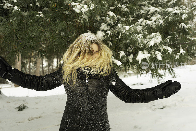 漂亮的女人抖掉头发上的雪