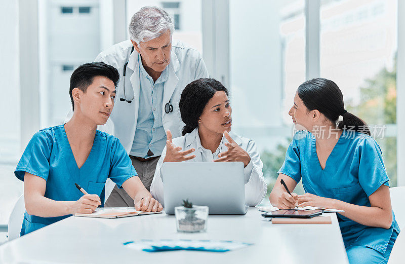 一群医疗从业人员在医疗办公室用笔记本电脑工作