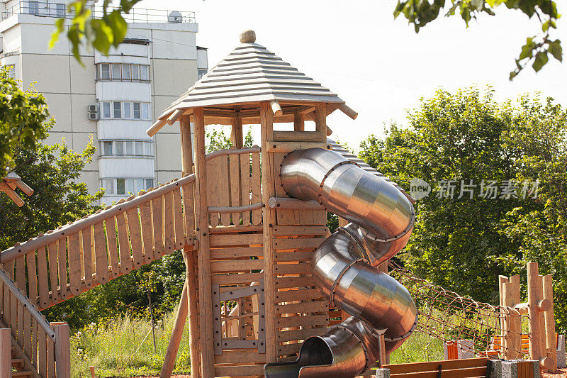 现代儿童户外游戏的游乐场，金属做的滑梯，木头做的金字塔