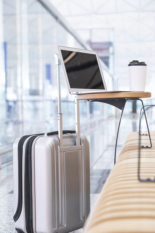 手提电脑，马克杯和行李在机场