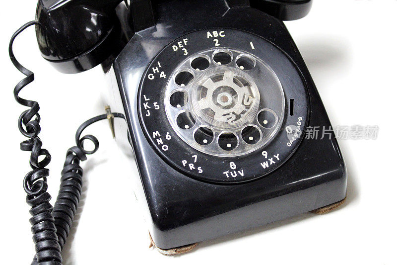 复古黑色旋转拨号电话与盘绕在古董店的线-白色背景