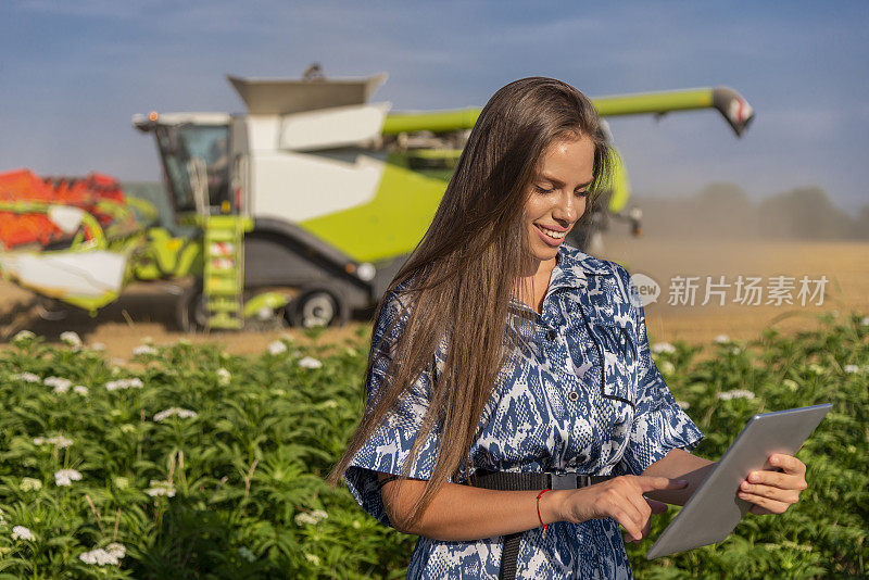 一位年轻的女性，一位农业工程师，用一台笔记本电脑控制着她田地里的收成