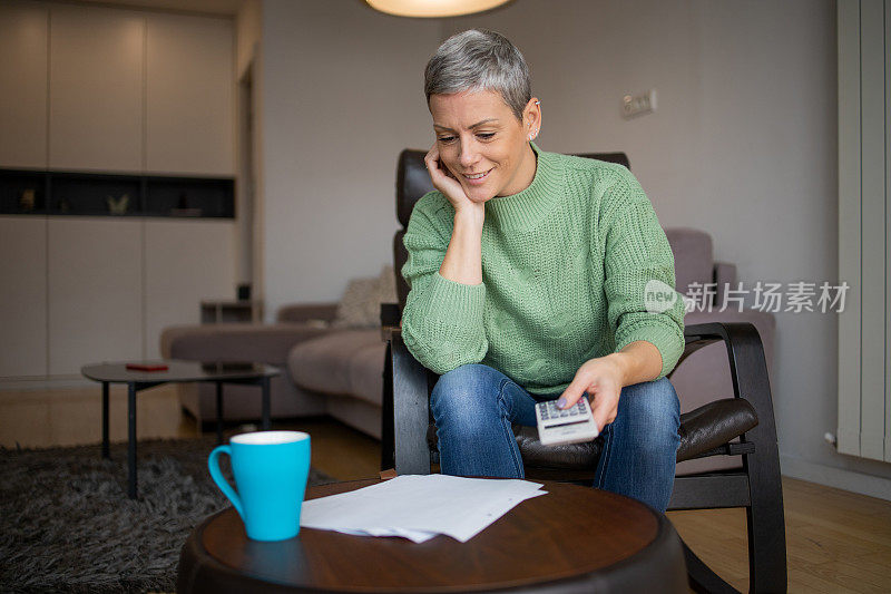 女人在查看账单和家庭财务时使用计算器