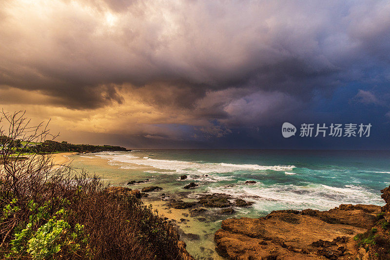 日落照亮的海洋上戏剧性的风暴单体系统的海岸海景