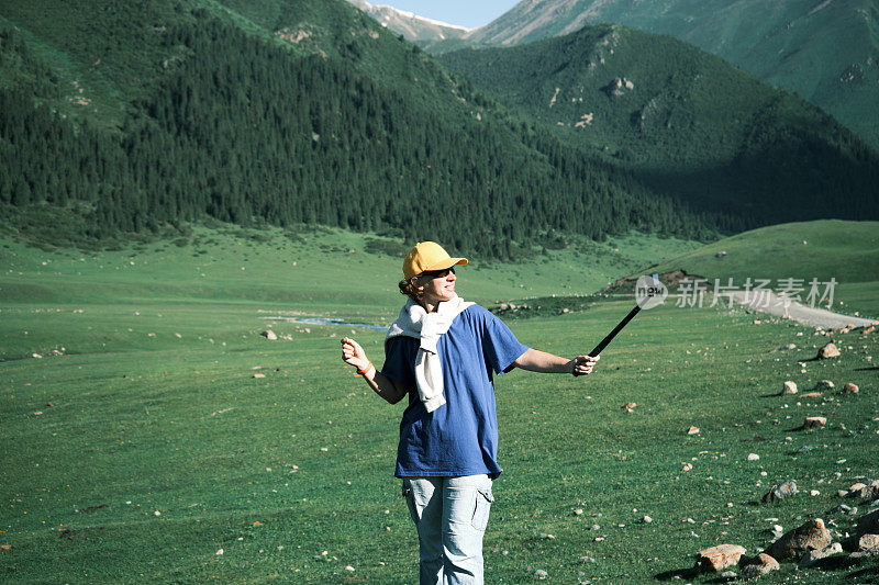 一位背包客正在拍摄她在山河上的旅行视频