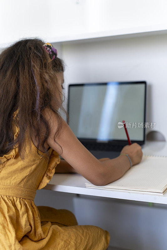一个正在学习的女孩。小学生用电脑学习。女学生在家做作业。回到学校。
