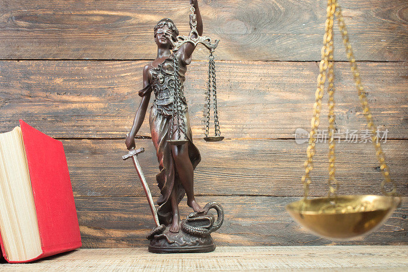 法律概念-在法庭或执法办公室的桌子上打开法律书，天平，忒弥斯雕像。