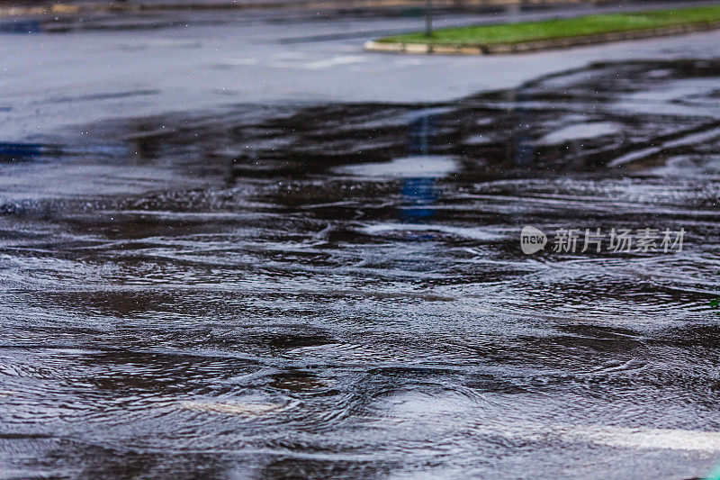 路上的水坑。多雨的天气。雨