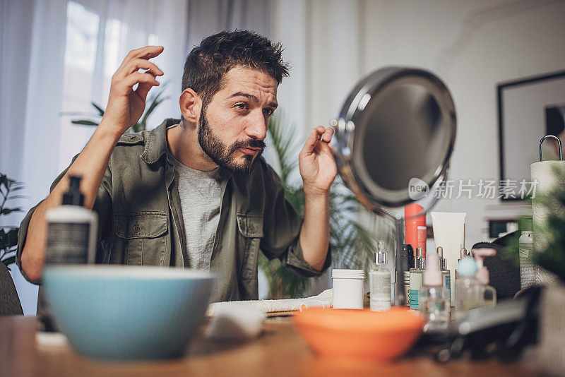 男人在家里造型他的头发并涂发胶