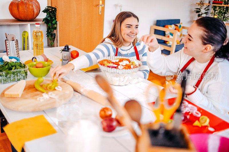 女孩们在家里做披萨玩得很开心