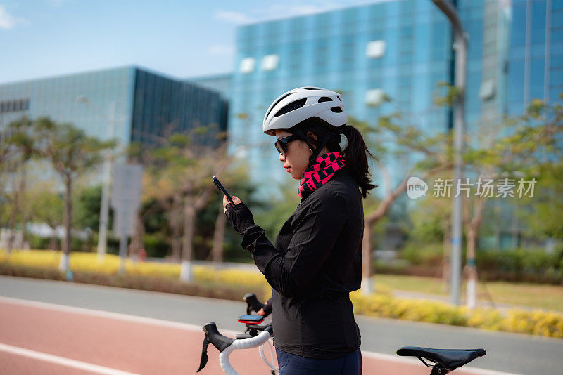 女公路自行车骑手使用智能手机