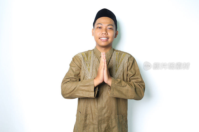 一名亚洲穆斯林男子微笑着对着镜头致意，镜头被隔离在白色背景中