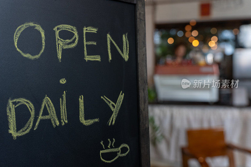 咖啡店的木板上写着“每天营业”两个字。