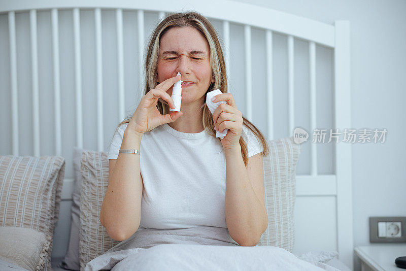 生病的年轻女子使用鼻腔喷雾剂