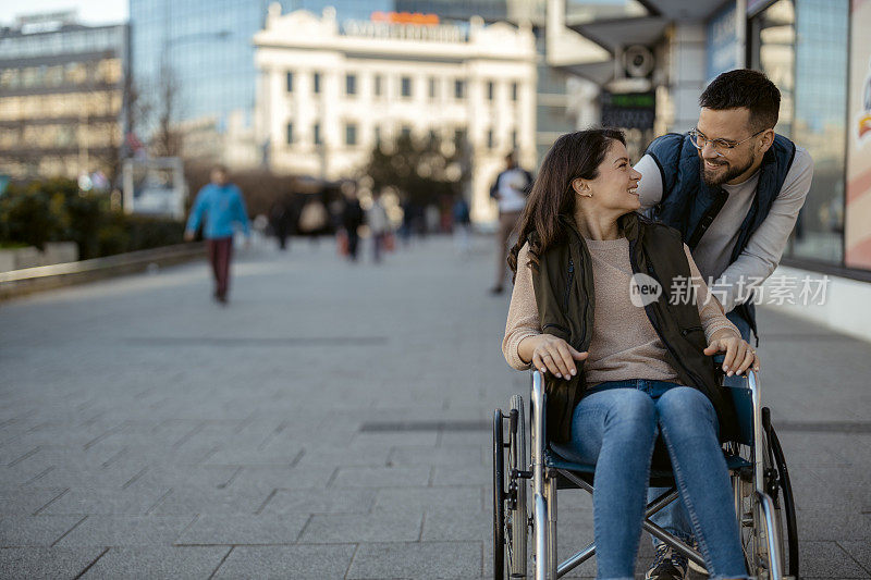 坐在轮椅上的残疾妇女和她的男朋友在户外