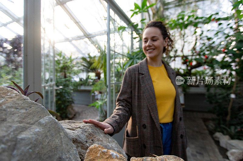 一个年轻的白人妇女在植物园里玩得很开心